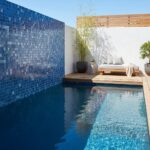 Blue mosaic tiles with textured surface, surrounding a swimming pool.