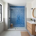 Bright blue mosaic tile with textured surface in a modern shower enclosure.