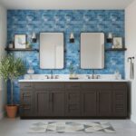 Blue textured ceramic tiles on the wall behind a double vanity with two mirrors and wall-mounted lights.