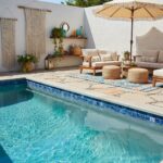 A relaxing outdoor space featuring a swimming pool, comfortable seating, and stylish decor.