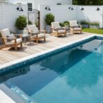 Bright blue swimming pool with clear water and surrounding wooden deck.