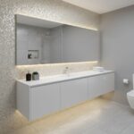 Bright, sleek bathroom with gray textured tiles and a large mirror.