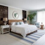 Bright, airy room with a coastal theme, featuring a large bed, white and blue accents, and tropical plants.