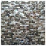 Reflective mosaic tile in beige, gray, and metallic tones with a textured, shiny surface.