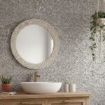 Gray mosaic tile with textured surface, complemented by greenery and natural wood accents.