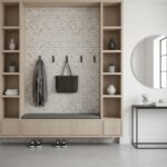 Neutral beige mosaic tile wall with hooks and storage bench.