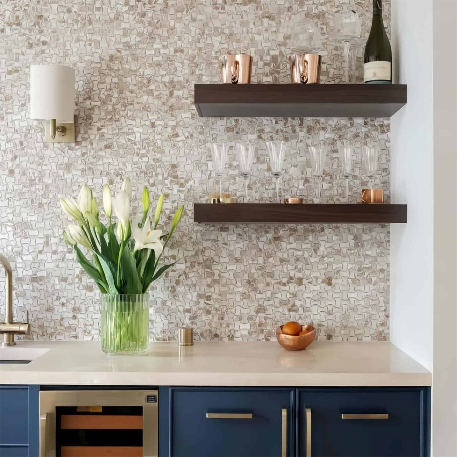 Beige mosaic tile with textured surface, dark wood shelves, and blue cabinet doors.