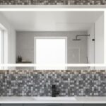 Gray mosaic tile with textured surface surrounding a large bathroom mirror.