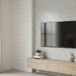 Bright, white shiplap wall with textured surface, featuring a mounted flat-screen TV, a wooden console, and decorative access.