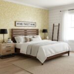 A cozy bedroom featuring a yellow floral wallpaper accent wall, wooden bed frame, white bedding, and modern black lamps for a.