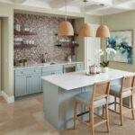 Bright blue cabinetry with mosaic tile backsplash and natural rattan pendant lights.