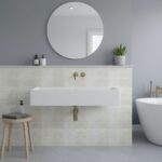 Gray wall tile with subtle texture and matte finish, complemented by a sleek white sink and minimalist decor.