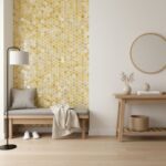 Golden mosaic tile wall with textured, shiny surface in a minimalist room setting.