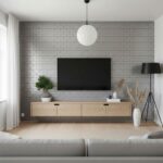 A sleek living room featuring a gray brick wall with a flat-screen TV, complemented by a light wood console, potted plant, an.