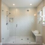 Bright mosaic tile shower with textured surface and neutral tones.