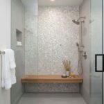 Bright white circular mosaic tiles with subtle texture, creating a clean and modern look.