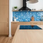 Blue mosaic tile backsplash with textured surface in contemporary kitchen.