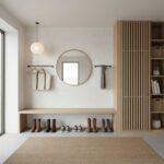 Bright entryway featuring a round mirror, wooden storage unit, and neutral-toned decor.