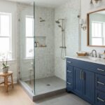 Hexagon tile in soft neutral tones with textured surface, modern shower fixtures, and a sleek blue vanity.