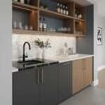 Kitchen cabinet with black lower cabinets and wood upper cabinets, featuring a white countertop and decorative backsplash.