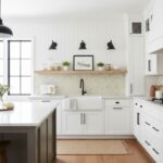 Bright white kitchen with a light green mosaic tile backsplash, black fixtures, and modern decor.