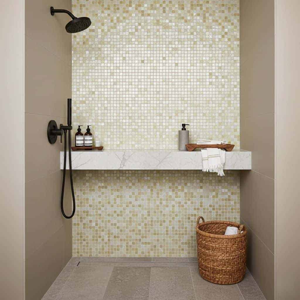 Mosaic tile wall in neutral beige and cream tones with textured surface.