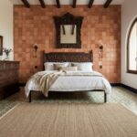 Warm terracotta-colored textured tiles on the wall behind the bed.