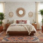 Bright bedroom with textured wall, woven wall decor, and patterned area rug. Features a cozy bed with colorful pillows and na.