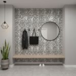Black and white checkered tile wall with a round mirror, black hooks, and a wooden bench in a modern entryway.