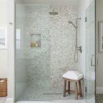 Elegant marble-look shower tiles with a subtle shimmer and textured surface.