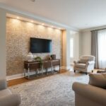 Beige textured tile wall behind the TV, adding warmth and elegance to the living room. Smooth surface with a natural stone ap.