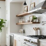 Bright white kitchen featuring textured tile backsplash, wooden open shelves, and stainless steel appliances.