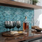 Close-up of blue glass mosaic tiles on kitchen backsplash, glossy and textured surface with reflections.
