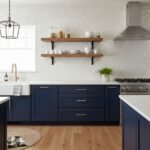 White textured ceramic tiles with a subtle pattern, complementing navy blue cabinets and wooden shelves for a contemporary ki.