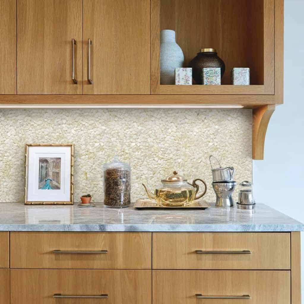 Textured beige wall tile behind kitchen countertop.