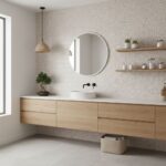 Bright, neutral-toned bathroom with light wood vanity, round mirror, and floating shelves. Minimalist style with textured wal.